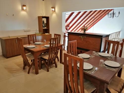 a dining room with a wooden table and chairs at Melford Nuwaraeliya in Nuwara Eliya