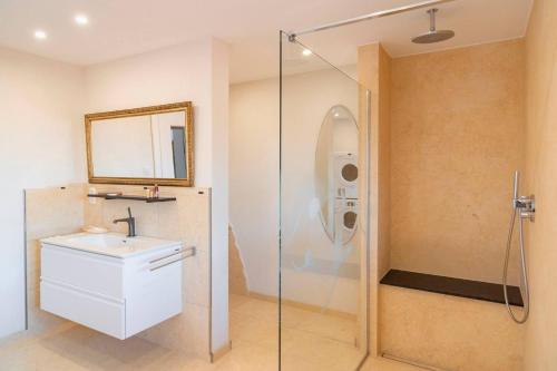 a bathroom with a sink and a glass shower at Roger`s Ferienwohnung in Dießen am Ammersee