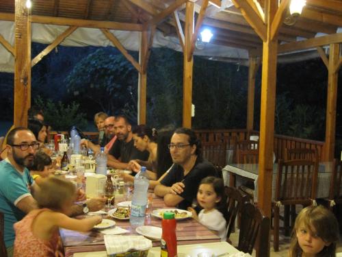 a group of people sitting at a table eating at Baris Pension & Bungalows in Cıralı