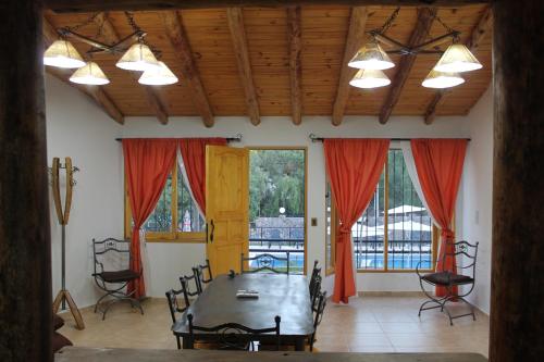 ein Esszimmer mit einem Tisch und roten Vorhängen in der Unterkunft Complejo Turistico Alfombra Magika in Mendoza