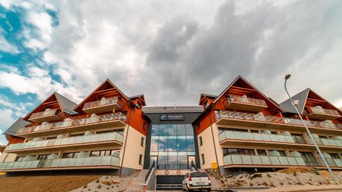 a building with a car parked in front of it at Triventi Mountain Residence, Sun & Snow in Karpacz