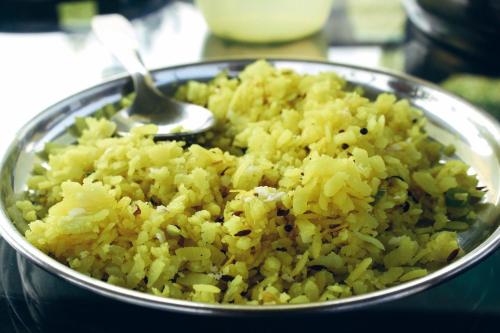a bowl of yellow rice with a spoon in it at StayVista at Aashirwaad Villa in Coonoor