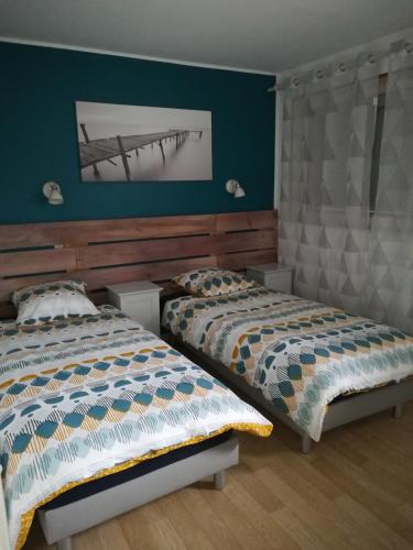 two beds in a bedroom with green walls at Maison Chez Lili à 200 m de la plage ,jardin privé et clos in Gravelines