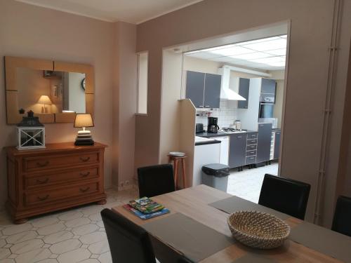 a kitchen and dining room with a table and chairs at Maison Chez Lili à 200 m de la plage ,jardin privé et clos in Gravelines