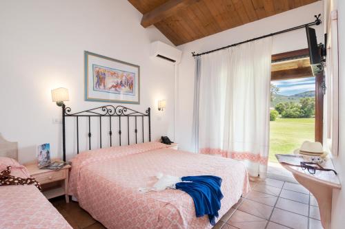 a bedroom with a bed and a large window at TH San Teodoro - Liscia Eldi Village in San Teodoro