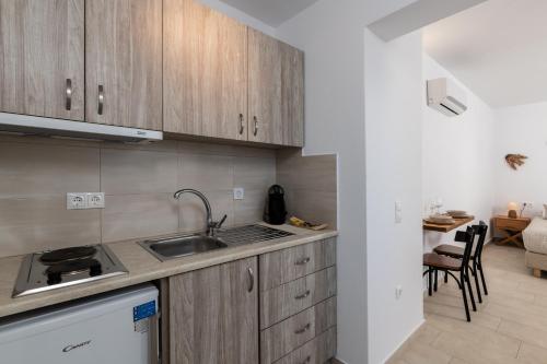 a kitchen with wooden cabinets and a sink at Secret Garden Apartments in Mýkonos City