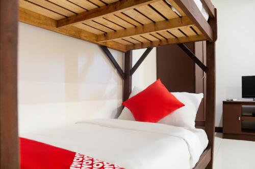 uma cama com almofadas vermelhas e brancas em OYO 153 Espacio de Clarita Hometel em Davao