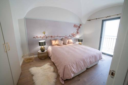 um quarto com uma cama rosa com 2 candeeiros e um tapete em CASA VALDES 16, APTO. 2 em Cáceres