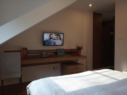 a bedroom with a bed and a tv on a wall at Ranczo Czerwony Młyn in Zdów