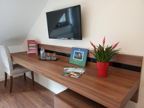 a wooden table with a television on a wall at Ranczo Czerwony Młyn in Zdów