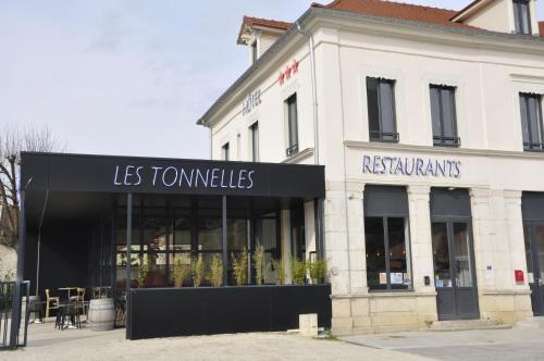 a building with a sign for a restaurant at Les Tonnelles in Bar-sur-Seine