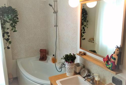 een badkamer met een bad, een wastafel en een spiegel bij La Casetta di Perugia in Perugia
