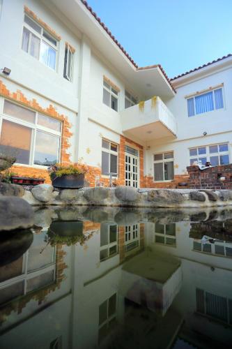 a house and its reflection in the water at The house behind stream in Dahu