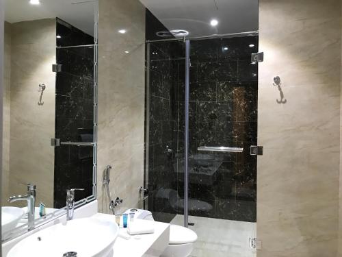 a bathroom with two sinks and a glass shower at Ayan Hotel in Riyadh