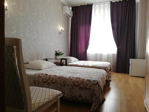 una camera d'albergo con due letti e una finestra di Mini-Hotel Sultan a Astana