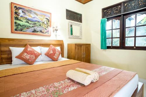 a bedroom with a large bed with two towels on it at Shindu Home Stay in Ubud