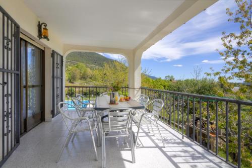 a patio with a table and chairs on a balcony at aMatalasviñas in Piedralaves
