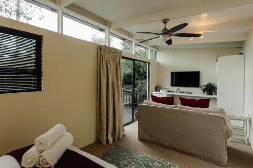 a living room with a couch and a tv at L'auberge Country Hideaway in Port Elizabeth