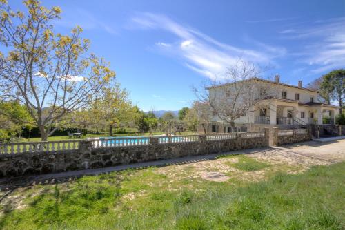 a stone fence in front of a house at aMatalasviñas in Piedralaves