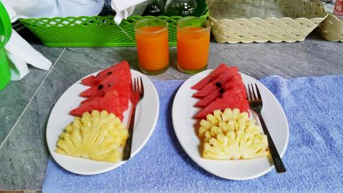 two plates with slices of watermelon and fruit on them at Baramate Khao Lak - SHA PLUS in Khao Lak
