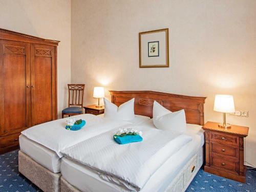 a bedroom with a large white bed with two blue trays on it at Villa Sommerfreude in Bansin