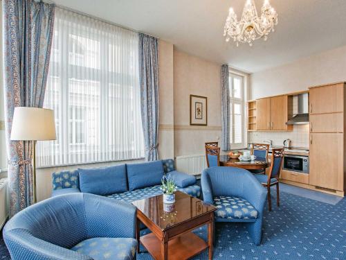a living room with blue furniture and a dining room at Villa Sommerfreude in Bansin