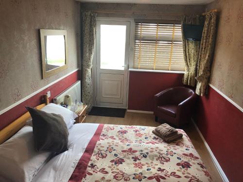 a bedroom with a bed and a chair and a window at Central Hotel in Sutton in Ashfield