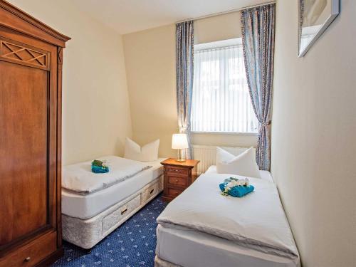 two beds in a small room with a window at Villa Sommerfreude in Bansin