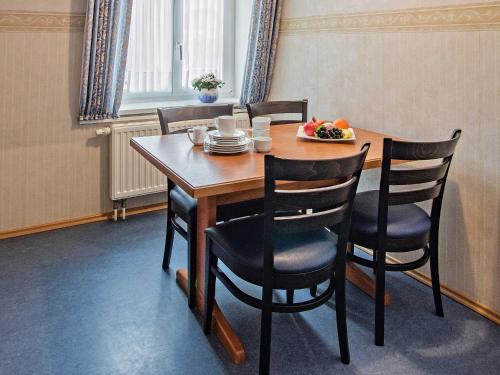 a wooden table with chairs and a plate of fruit on it at Villa Sommerfreude in Bansin