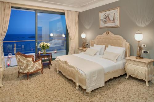 a bedroom with a large bed and a large window at Royal Princess Hotel in Dubrovnik