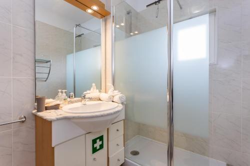 a bathroom with a sink and a shower at Três Castles Beach Apartment 3 in Portimão