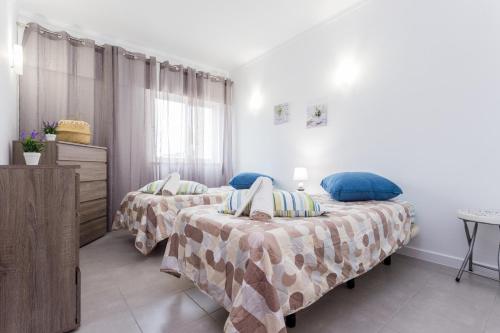 a bedroom with two beds and a table at Três Castles Beach Apartment 3 in Portimão