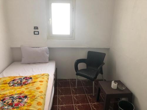 a bedroom with a bed and a chair and a window at Colour Holidays in Cairo