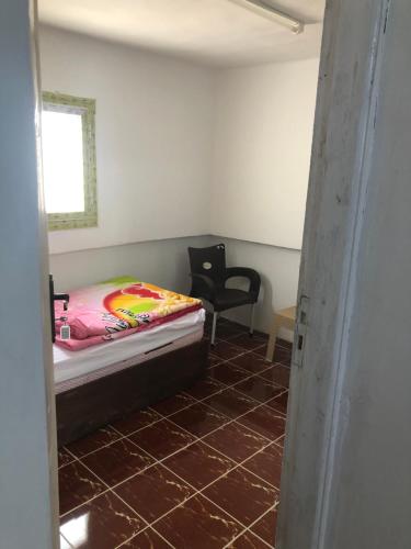 a small bedroom with a bed and a chair at Colour Holidays in Cairo