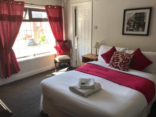 ダーリントンにあるThe Chequers Innのベッドルーム1室(赤毛布付きの大型ベッド1台付)