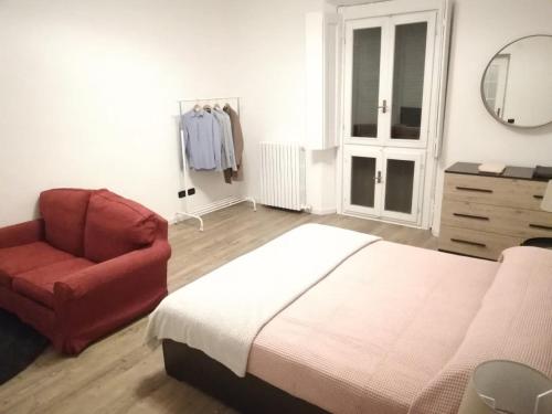 a bedroom with a bed and a chair and a mirror at CENTRO e PARCO 10 min - flat in Monza in Monza