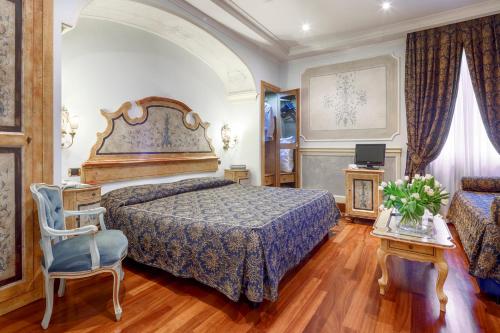a bedroom with a large bed and a chair at Hotel Villa San Pio in Rome