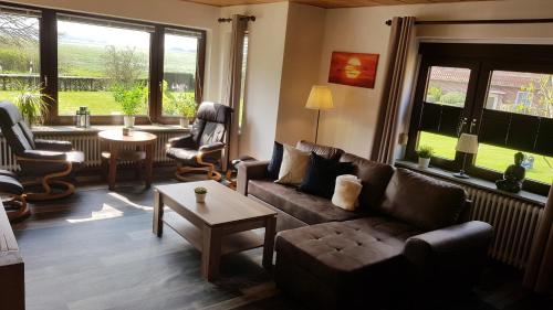 a living room with a couch and chairs and a table at Gästehaus Zur alten Post in Dornumersiel
