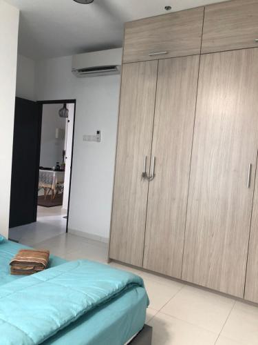 a bedroom with a bed and wooden cabinets at Kyra The Heights Residence Condo Ayer Keroh Melaka WiFi, Netflix & Pool in Ayer Keroh