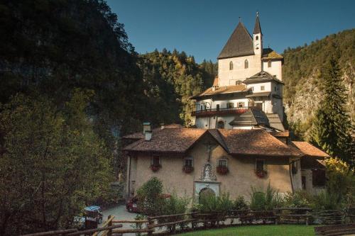 a building with a castle on top of it at Alpen Garten Hotel Margherita in Rumo
