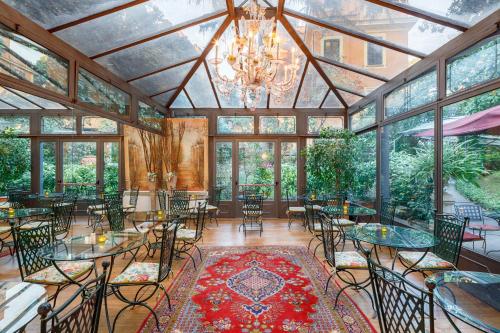 uma sala de jantar com mesas e cadeiras e um lustre em Hotel Villa San Pio em Roma