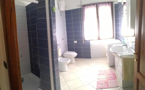 トルトリにあるMussilimbrosuの青いタイル張りのバスルーム(トイレ、シンク付)