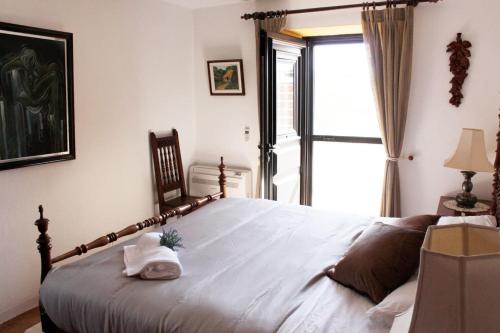 um quarto com uma grande cama branca e uma janela em Casa do Vale da Pedra em Santarém