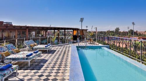 a pool on the roof of a hotel with chairs at 2Ciels Boutique Hôtel in Marrakesh