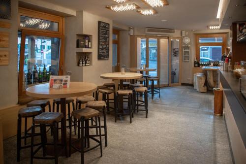 a bar with tables and stools in a restaurant at Hotel Compagnoni in Livigno