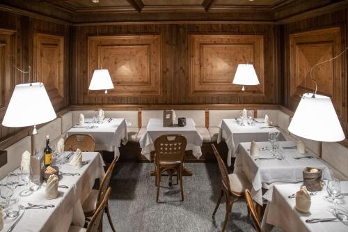 a restaurant with white tables and chairs and lights at Hotel Compagnoni in Livigno
