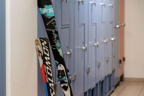 a snowboard is hanging next to a row of lockers at Hotel Compagnoni in Livigno