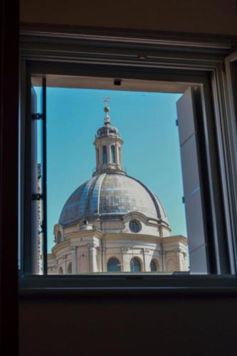 a building with a domed roof is seen through a window at AmaMantua in Mantova