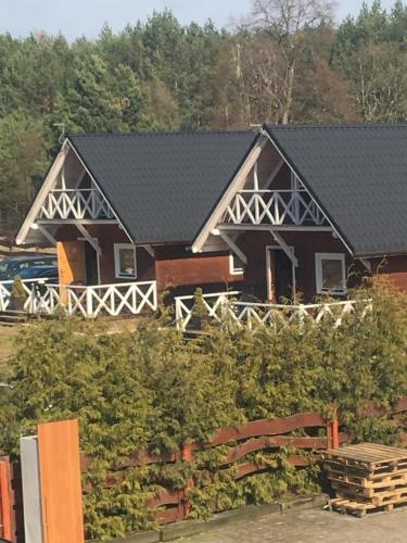 a large brown house with a black roof at Agroturystyka Stajnia Zwierzyniec in Międzychód