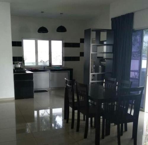 a kitchen and dining room with a table and chairs at Jauzara Homestay Berkolam Renang in Port Dickson
